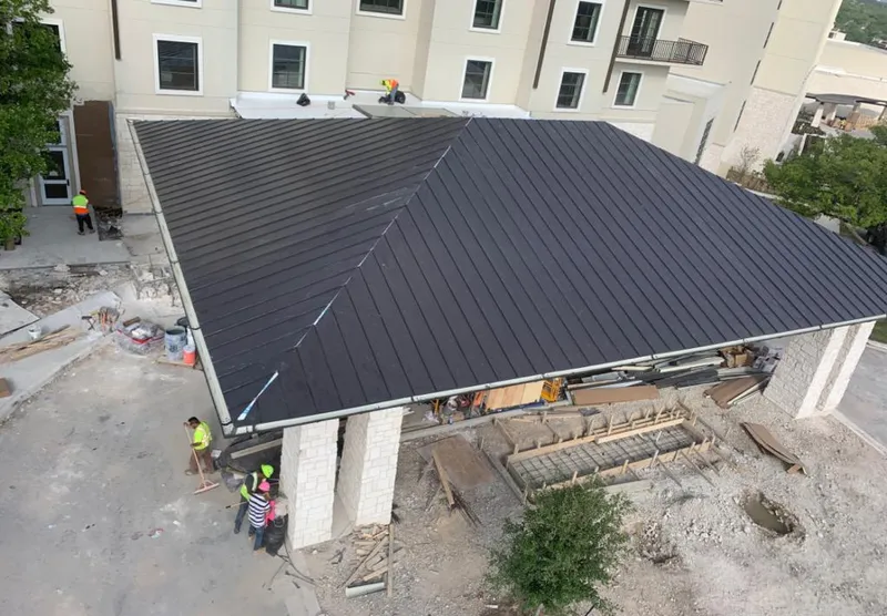 Metal roofing installation team working on a commercial building in Bear